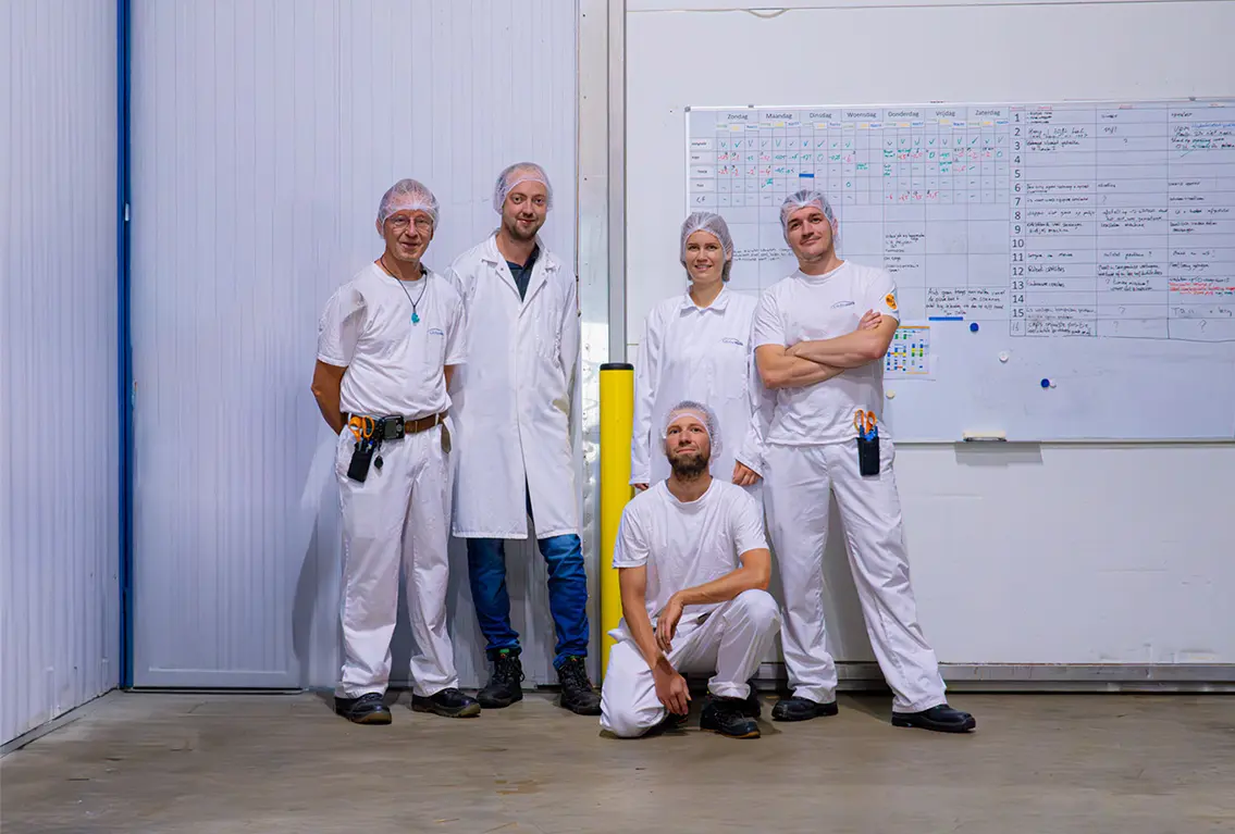 Medewerkers kwaliteitsafdeling in witte jassen en mutsjes.